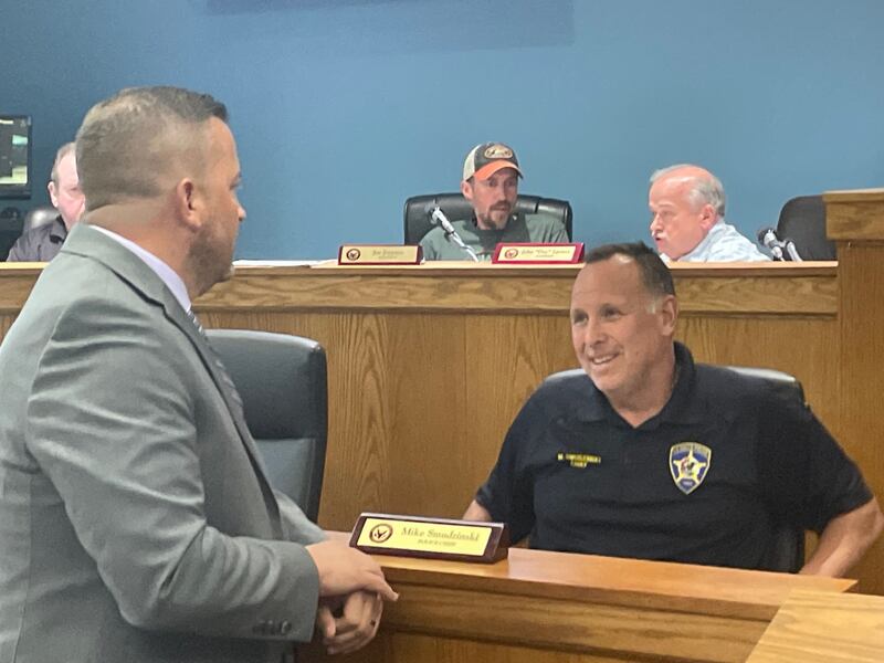 Incoming La Salle Police Chief Jason Stubler (standing, left) chats with retiring Chief Mike Smudzinski before Stubler's oath of office Monday, Sept. 15, 2025, before the La Salle City Council.