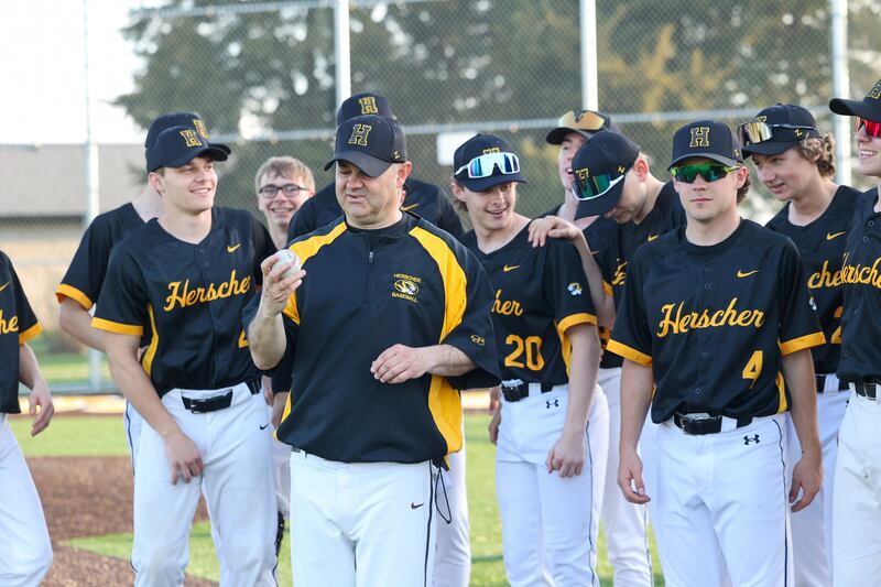 Herscher head coach Eric Regez smiles as he looks at the game ball, with the number 800 written on it, following his 800th career win after the Tigers earned a 21-0 victory over Grant Park on Wednesday, April 23, 2025.