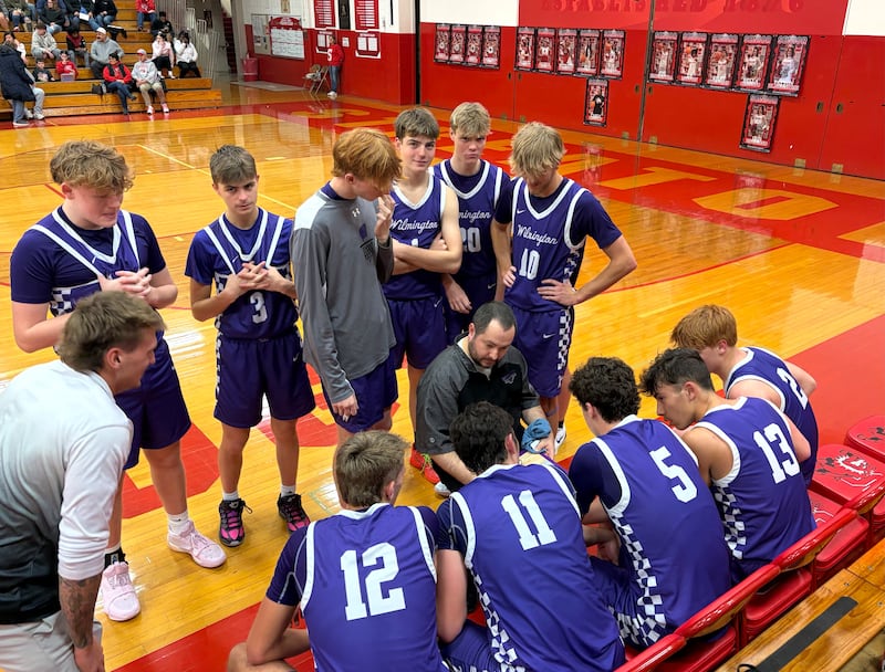 Wilmington boys basketball coach Doug Krop (center) talks things over with his Wildcats during a timeout Friday, Jan. 9, 2026, at Pops Dale Gymnasium in Streator.