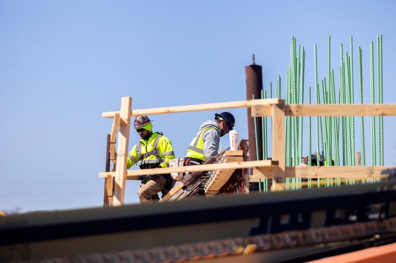 Workers are extending old railroad piers up for the building of the Project Rock pedestrian bridge Tuesday, April 8, 2025, in Dixon.