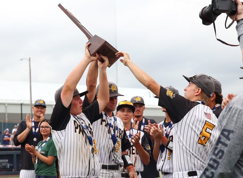 Putnam County's Traxton Mattingly and Johnathan Stunkel, center, present the second place trophy to the team following the Panthers' 10-0 loss in five innings to Tremont in the IHSA Class 1A State championship on Saturday, June 13, 2026, at the University of Illinois in Champaign.