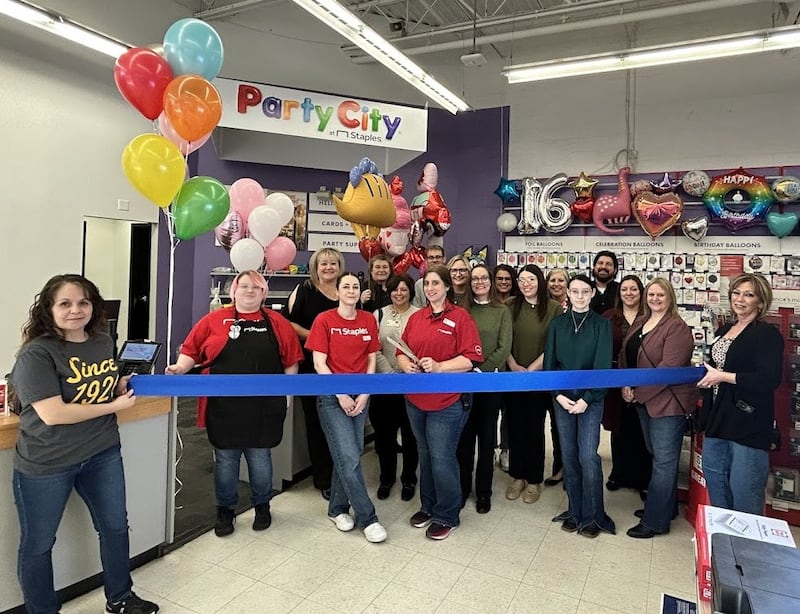 Members of the Illinois Valley Area Chamber of Commerce join staff in cutting the ribbon to celebrate the opening of the new Party City section inside Staples in Peru.
