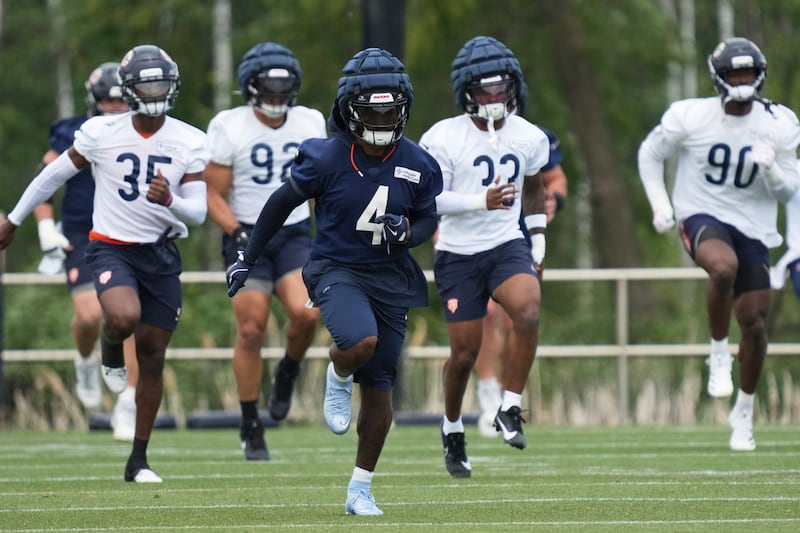 Chicago Bears running back D'Andre Swift (4) warms up with teammates during NFL football practice at Halas Hall in Lake Forest, Ill., Tuesday, June 3, 2025. (AP Photo/Nam Y. Huh)