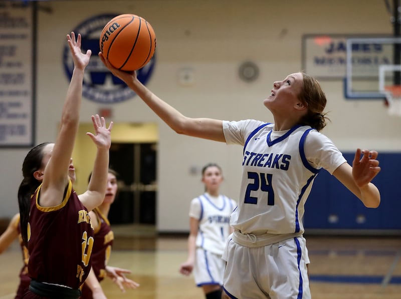 Woodstock's Aiyana Fourdyce (right) shoots the ball in front of Richmond-Burton's Morgan Splitt during a Kishwaukee River Conference girls basketball game on Wednesday, Jan. 28, 2026, at Woodstock High School.