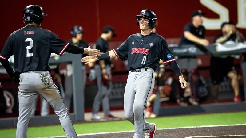NIU baseball players Wyatt Wawro (11) and Charlie Parcell celebrate during the Huskies' 12-10 win over Coastal Carolina on May 29, 2026, in Tallahassee, Florida. It was the first NCAA Tournament win in program history.
