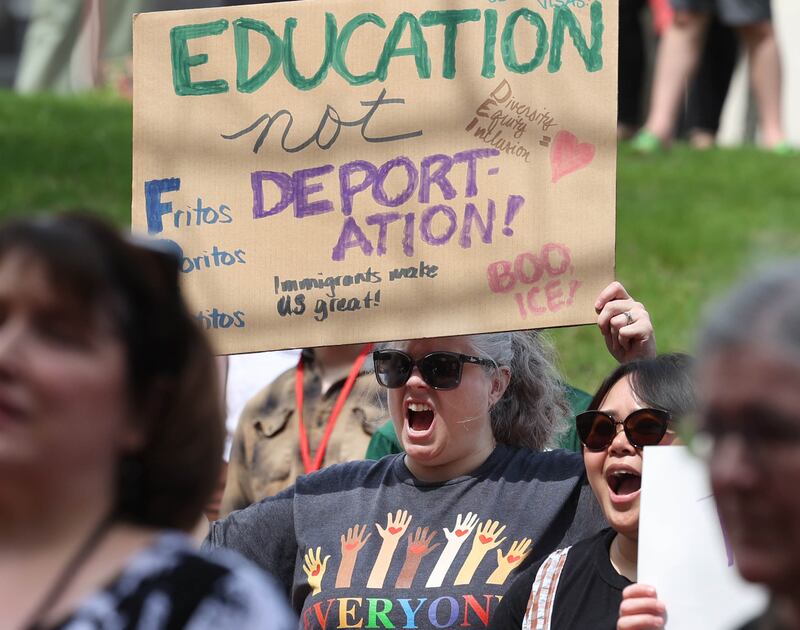 Attendees hold signs and cheer Wednesday, April 23, 2025, during a rally to support Northern Illinois University’s international students, faculty and staff, in front of Founders Memorial Library at NIU in DeKalb.