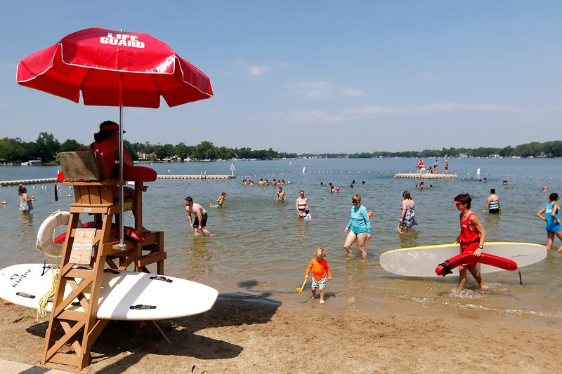 Lifeguards keep watch and people swim at Crystal Lake's Main Beach on Friday, June 21, 2024.