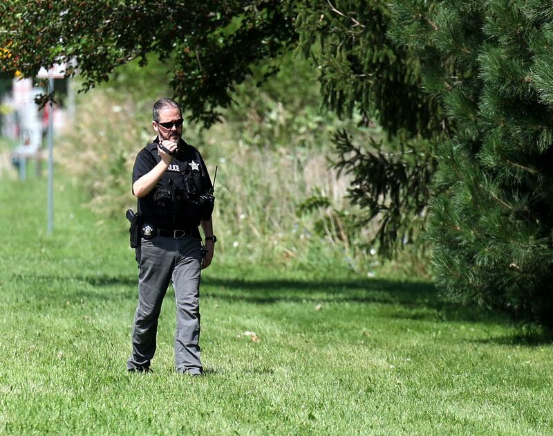 A DeKalb police officer takes video Monday, July 28, 2025, along the tree line that obscures a pond along the property on Ridge Drive between Sunflower Drive and Pickwick Lane as the investigation continues after a victim of an apparent drowning was recovered Sunday night.