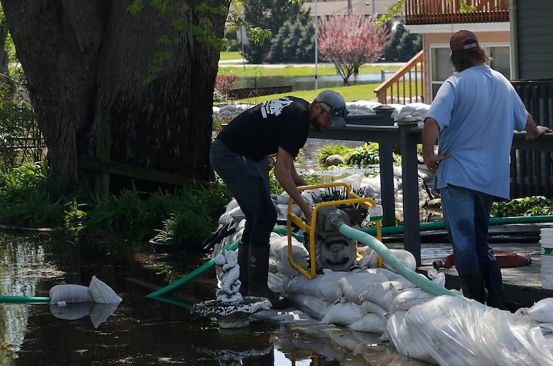 Volunteers work to protect a home in Holiday Hills  as flooding continues on the Fox River on Wednesday, April 22, 2026.