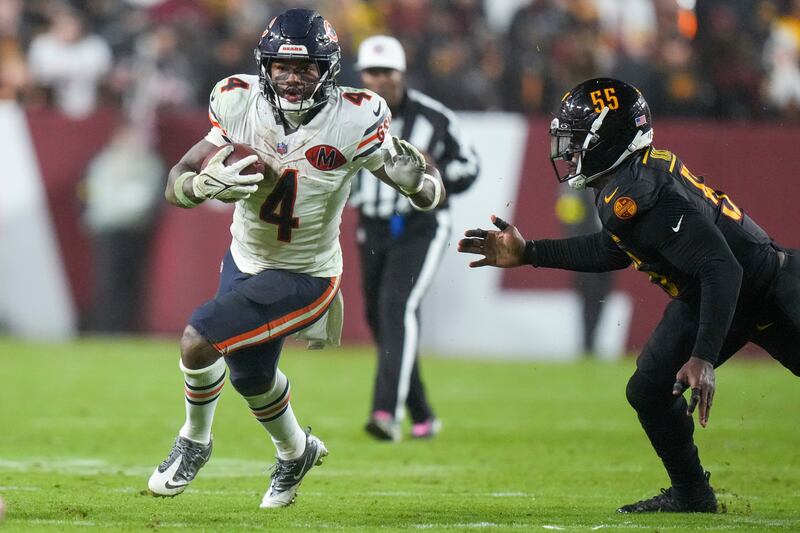Chicago Bears running back D'Andre Swift (4) gets away from Washington Commanders defensive end Jacob Martin (55) during the second half of an NFL football game Monday, Oct. 13, 2025, in Landover, Md. (AP Photo/Stephanie Scarbrough)