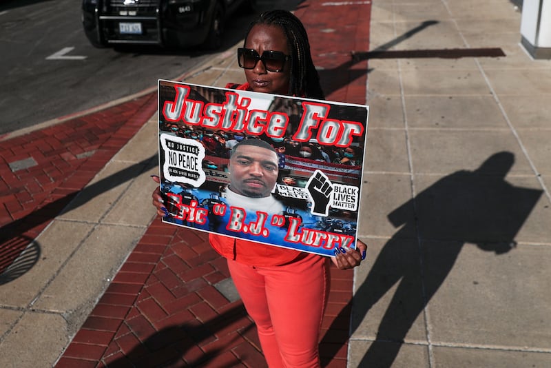 Nicole Lurry holds a sign calling for further investigation into the death of her husband Eric Lurry, a Joliet resident who died while in police custody, on Friday, Sept. 17, 2021, outside of the District Attorney's Office in Joliet, Ill.