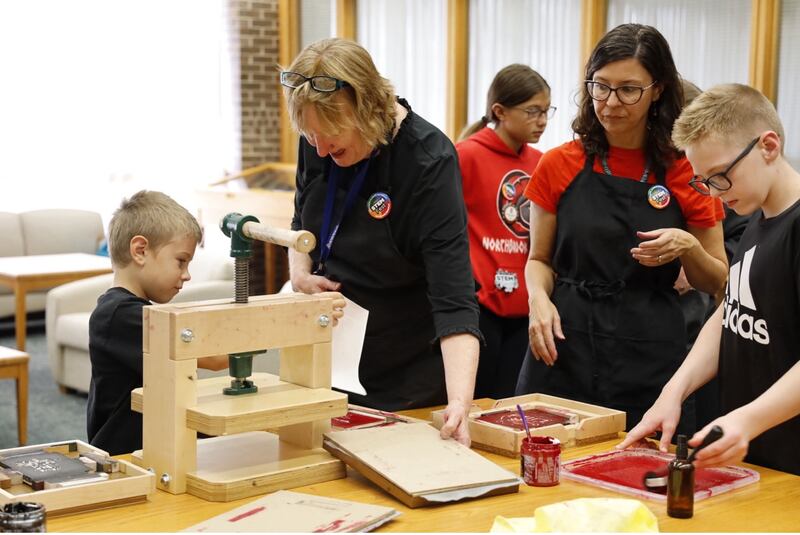 STEM Fest visitors use the BookBeetle printing press to make their own prints.