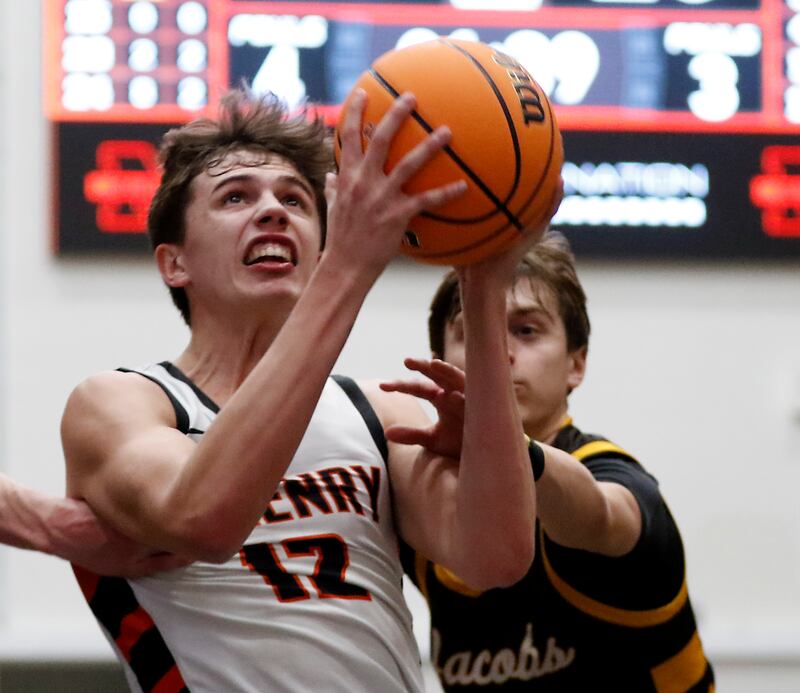 McHenry's Caleb Jett drives to the basket against Jacobs' Nolan Roper during an IHSA Class 4A McHenry Regional basketball game on Wednesday, Feb. 26, 2025, at McHenry High School.
