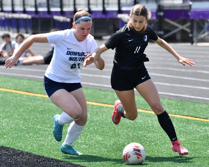 Downers Grove North’s Jordyn Sashin (11) moves the ball ahead of Downers Grove South’s Mallory Crowley during a game on May 10, 2025 at Downers Grove North High School in Downers Grove .