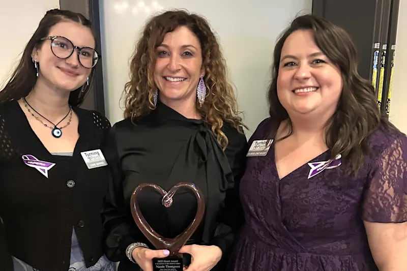 Nicole Thompson, center, health teacher at Bernotas Middle School in Crystal Lake, is honored with the inaugural Turning Point Heart Award on Friday, April 4, 2025, at this year’s Paint the Night Purple Gala. She's flanked by Lexie Zeppos, , left, Turning Point's outreach and prevention advocate, and Elissa Crowley, Turning Point's director of outreach and community engagement.