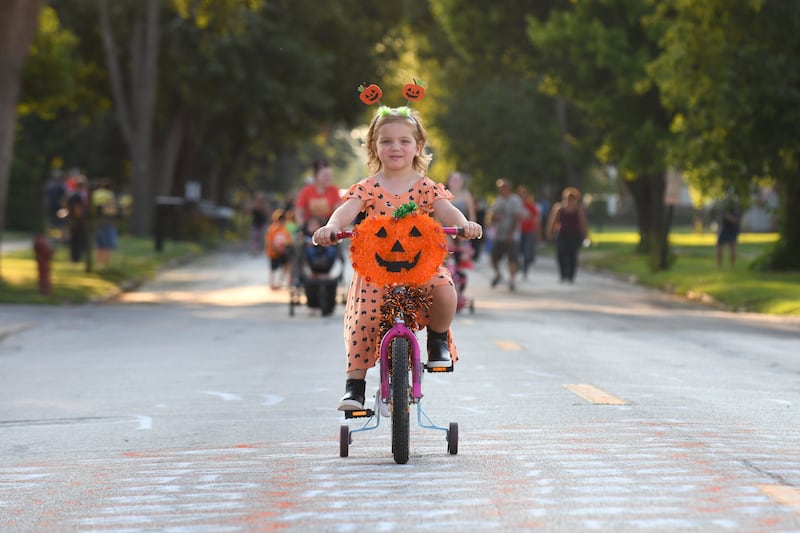 Brielle Busse, 4, of St. Anne, rides her bike down Station Street in St. Anne during the St. Anne Pumpkin Festival's Children and Golf Cart Parade in 2019.