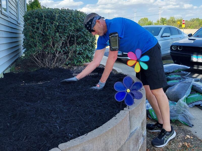 Dixon Supercenter manager Andy Neal putting down mulch in the flower beds.