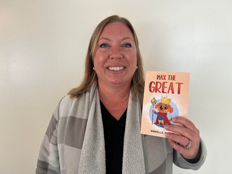 Local author Danielle Scott holds up her debut children's book 'Max the Great' that is available on Amazon, Barnes and Noble and Walmart.