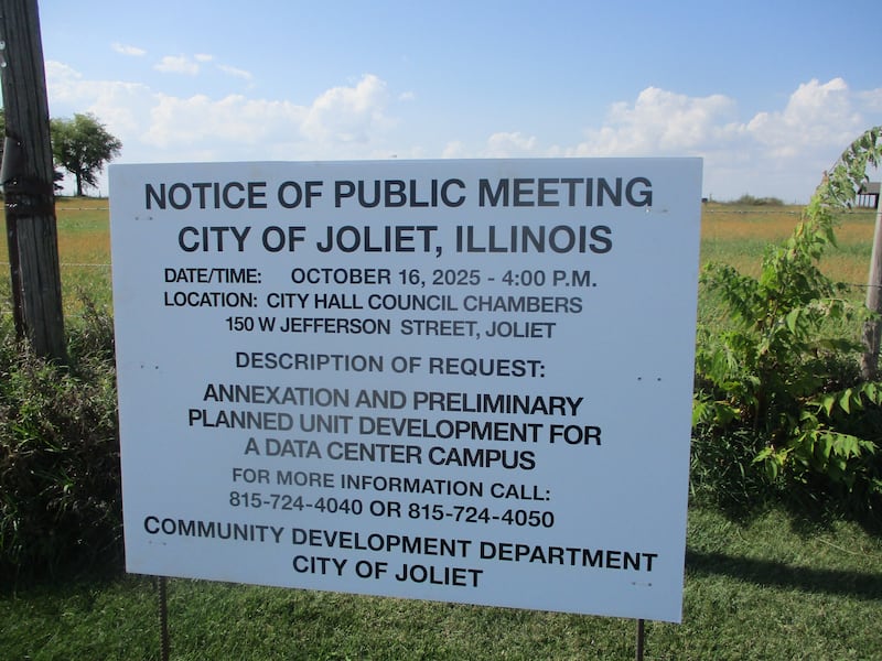 A sign posted on Ridge Road on the edge of a farm field gives notice of a Joliet Plan Commission meeting on a plan to develop the land for a data center. Oct. 3, 2025