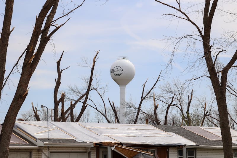The Aroma Park water tower appears through damaged trees on April 8, 2026, nearly one month after the EF-3 tornado.
