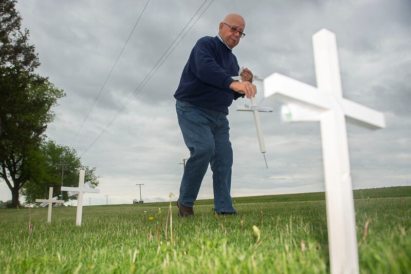The Rev. Jim Miller of East Jordan Methodist Church sets out crosses Wednesday, May 25, 2022, outside of the rural Sterling church. The crosses were built to recognize the war in Ukraine and are free to anyone.
