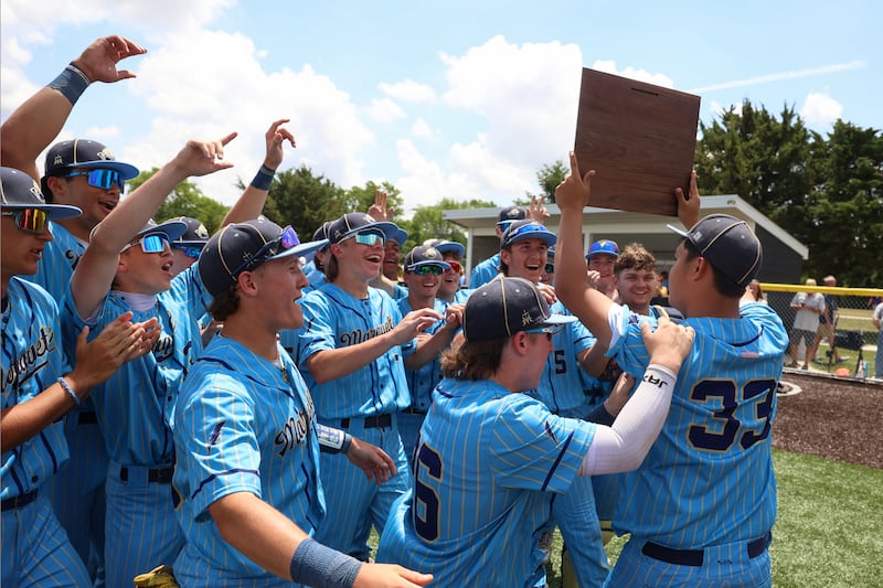 Marquette players celebrate with the IHSA Class 2A Herscher Sectional championship plaque following their 11-2 victory over Wilmington on Saturday, June 6, 2026.