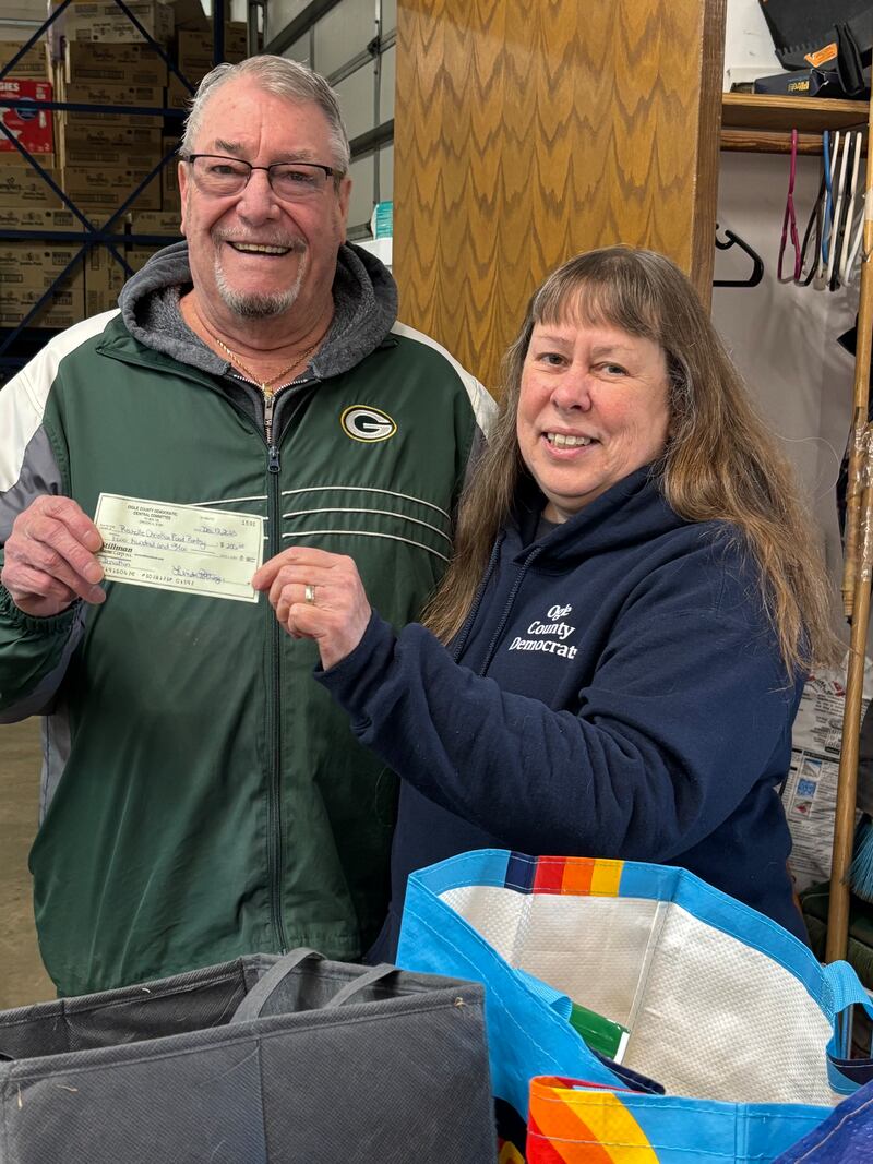 The Ogle County Democrats recently celebrated with a fundraiser and canned food collection drive in December. President Linda Pottinger presented Rochelle Christian Food Pantry President Cal Jacobs with a $200 check.