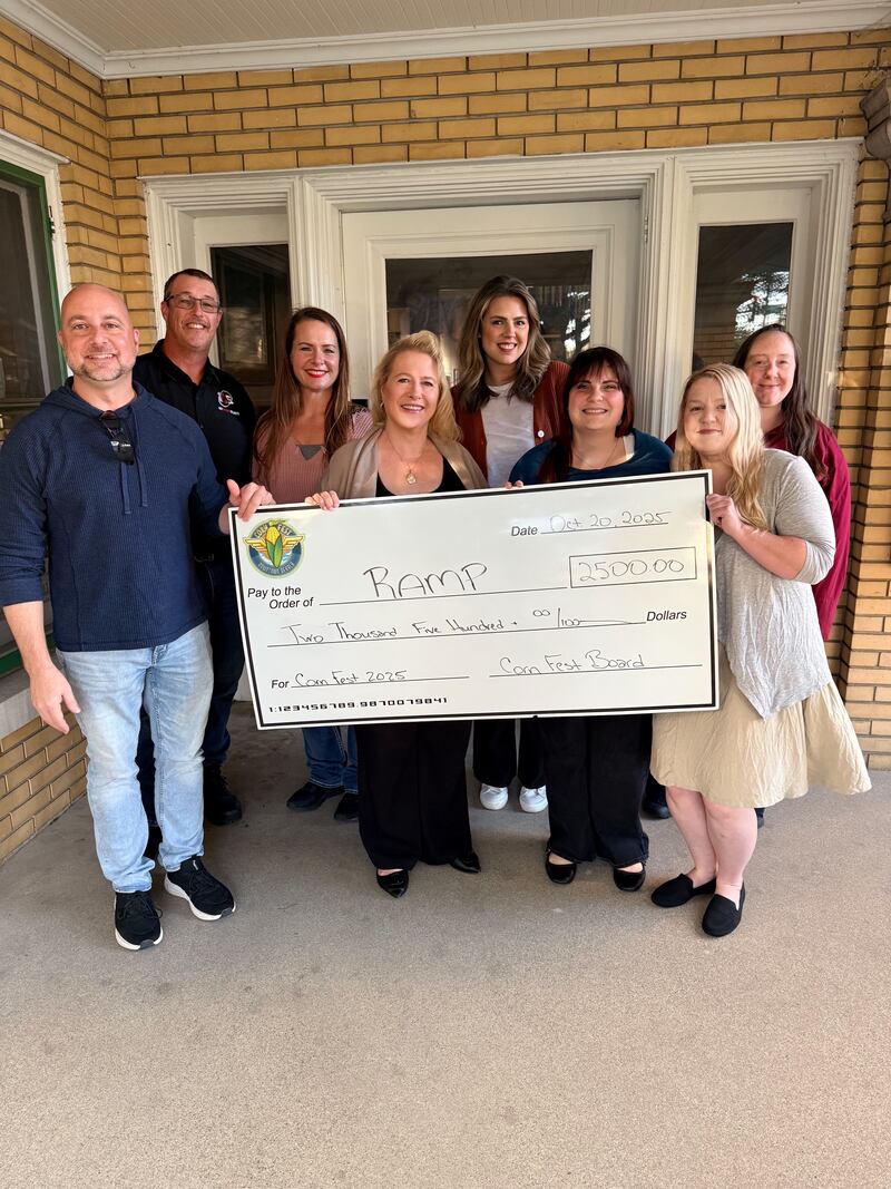 (From left) DeKalb Corn Fest board members Brian Oster, Brian Reynolds, Rachel McPheeters, Lisa Angel, Jessica Wexell, Autumn Gabriel, Nina Clausen and Jamie McClan, pose with a giant check for $2,500, to benefit RAMP disability services.