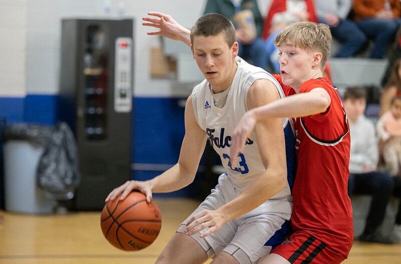 Faith Christian’s Logan Baker works against QC Christian’s Koltin Wolf Tuesday, Dec. 9, 2025.