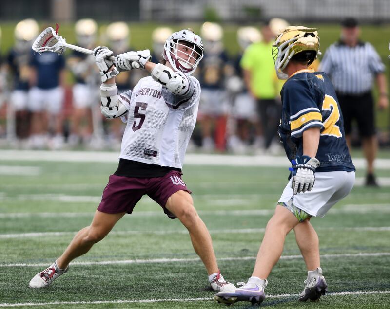 Wheaton Academy’s Tommy Sommer, left, shoots and scores in front of Neuqua Valley’s William Beaman during the third-place game of the boys lacrosse state finals at Hinsdale Central High School on Saturday, June 7, 2025.