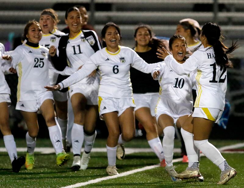 Harvard's Maria Mercado (right) is rushed by her teammates after she made a penalty kick to win the Kishwaukee River Conference Girls Soccer Tournament Championship Match against Richmond-Burton on Wednesday, May 7, 2025, at HRichmond-Burton High School in Richmond.