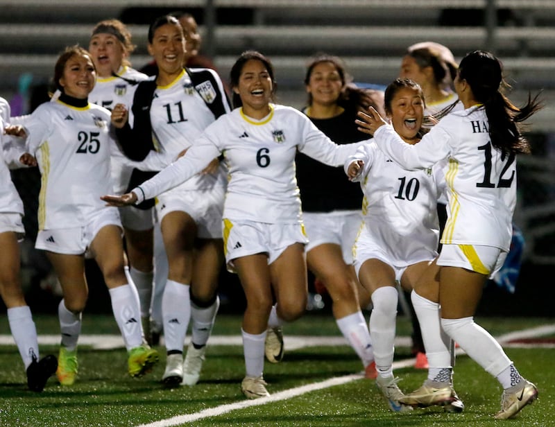 Harvard's Maria Mercado (right) is rushed by her teammates after she made a penalty kick to win the Kishwaukee River Conference Girls Soccer Tournament Championship Match against Richmond-Burton on Wednesday, May 7, 2025, at HRichmond-Burton High School in Richmond.