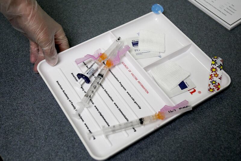 A certified medical assistant brings in vaccinations for a five-year-old patient which included a measles booster Wednesday.