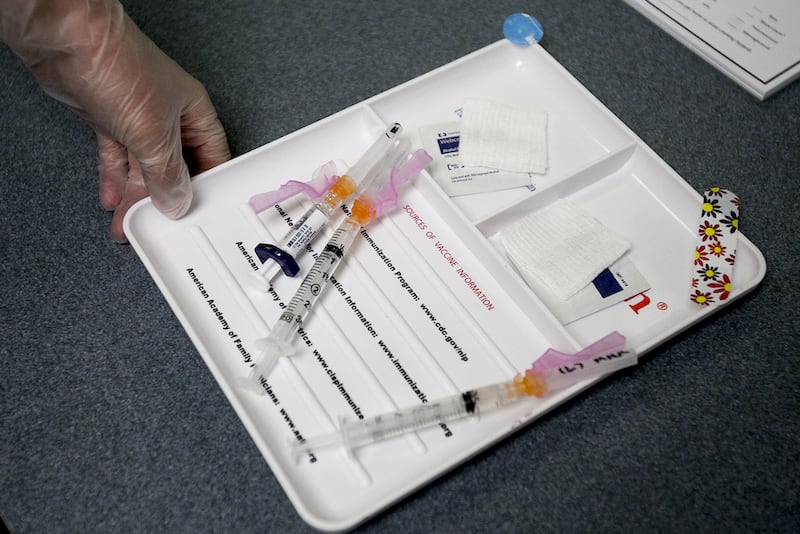 A certified medical assistant brings in vaccinations for a five-year-old patient which included a measles booster Wednesday.