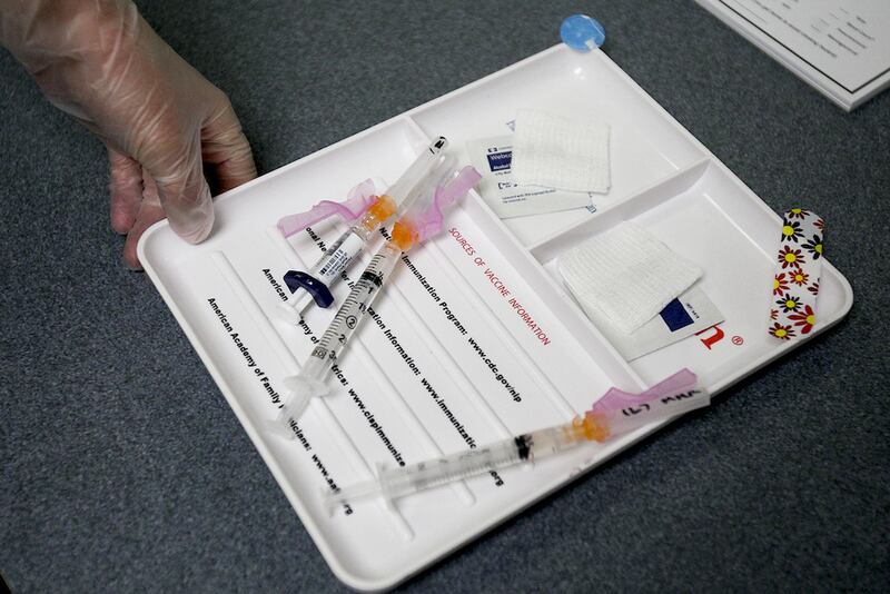A certified medical assistant brings in vaccinations for a five-year-old patient which included a measles booster Wednesday.