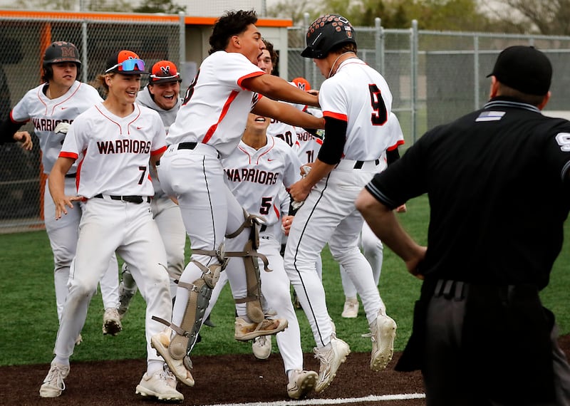 McHenry catcher Kyle Maness pushes his teammate, Carver Cohn, as he celebrates Cohn (right) scoring the game winning run during a Fox Valley Conference baseball game against Crystal Lake Central on Friday, May 2, 2025, at McHenry High School.