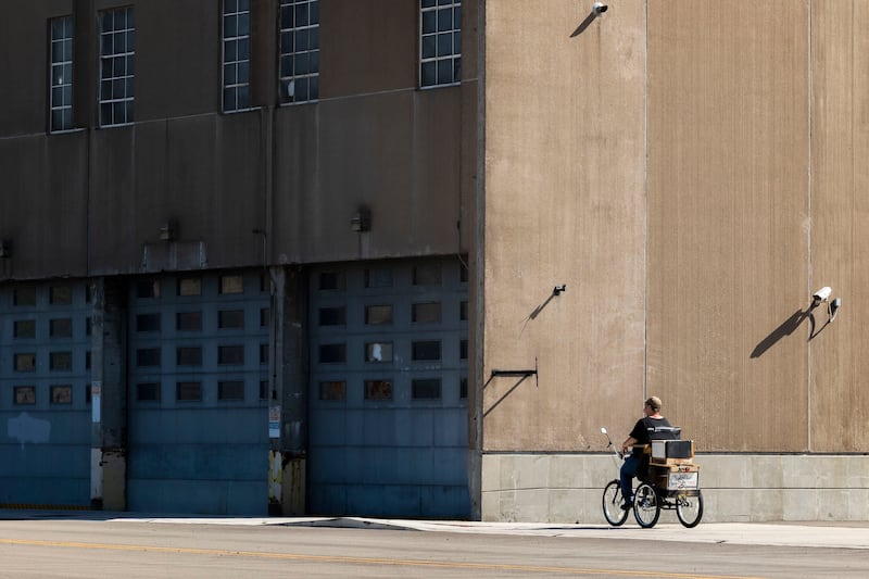 A cyclist rides past the former National Manufacturing building in Sterling Tuesday, Oct, 7, 2025. The building is situated in the designated River Edge Redevelopment Zone.