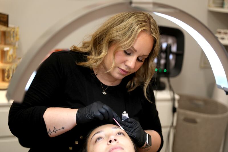 Danielle Murphy who owns Reveal Beauty & Wax Studio in Geneva, works with client Theresa Simon of St. Charles. Murphy took first place in an International Skin Competition in Atlanta, for brow lamination, second place for lash lift.