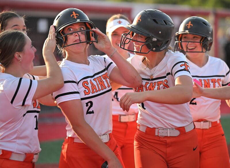 St. Charles East’s Addison Wolf reacts after being slapped in the helmet very hard by teammate Hayden Sujack in an IHSA Class 4A supersectional softball game against Barrington in Barrington on Monday, June 9, 2025. Sujack had just hit a home run and Wolf then hit a double.