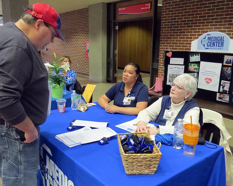 Amy Wiseman (left) and Lavita McKinzie discuss volunteer options for the CGH Auxiliary with a visitor at the 2026 Lifescape AmeriCorps Seniors RSVP Volunteer Fair on April 2, 2026, at Sauk Valley Community College. Wiseman was inspired to volunteer with the CGH Auxiliary after caring for her parents.