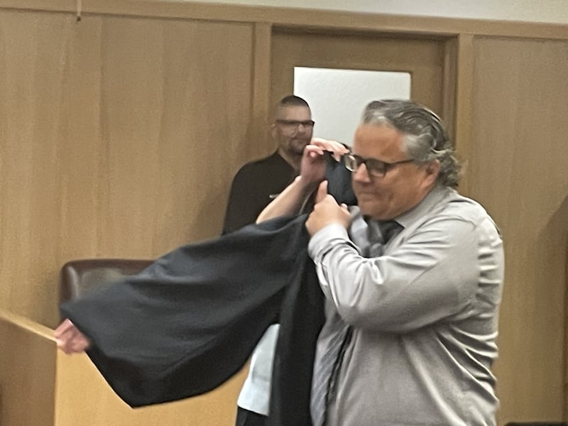 New Judge Greg Sticka dons his robe following a swearing-in ceremony Friday, May 15, 2026, in La Salle County Circuit. Holding up the robe, but hidden from view, is wife Julie (Barto) Sticka.
