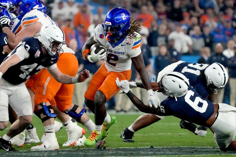 Boise State running back Ashton Jeanty (2) eludes the reach of Penn State safety Zakee Wheatley (6) during the second half of the Fiesta Bowl NCAA college football CFP quarterfinal game, Tuesday, Dec. 31, 2024, in Glendale, Ariz. (AP Photo/Rick Scuteri)