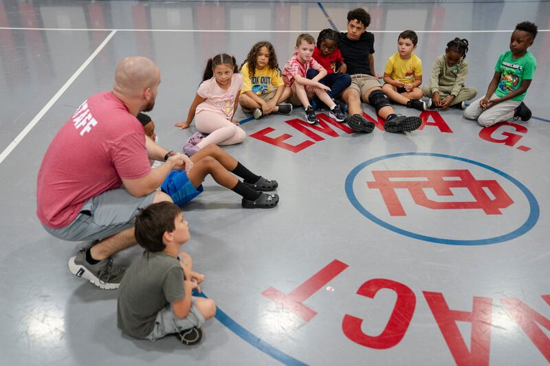 Thomas Boucher leads children in an activity during the East Providence Boys and Girls Club Summer Camp at Emma G. Whiteknact Elementary School on Thursday, July 10, 2025, in Providence R.I. (AP Photo/Sophie Park)