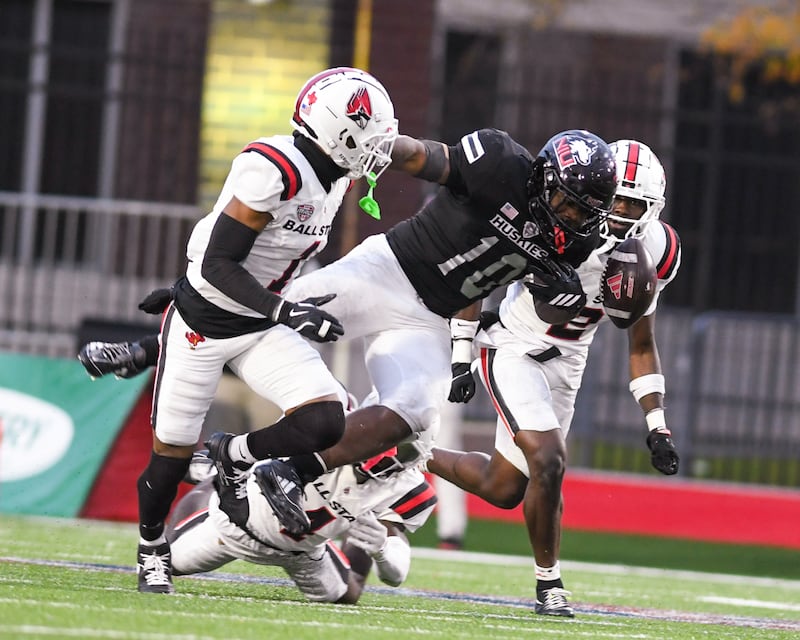 Northern Illinois University's running back Chavon Wright (10) gets tripped up by Ball State’s defender Eric McClain during the game forcing the ball to pop out during the game on Saturday Oct. 25, 2025, held at Huskie Stadium in DeKalb.