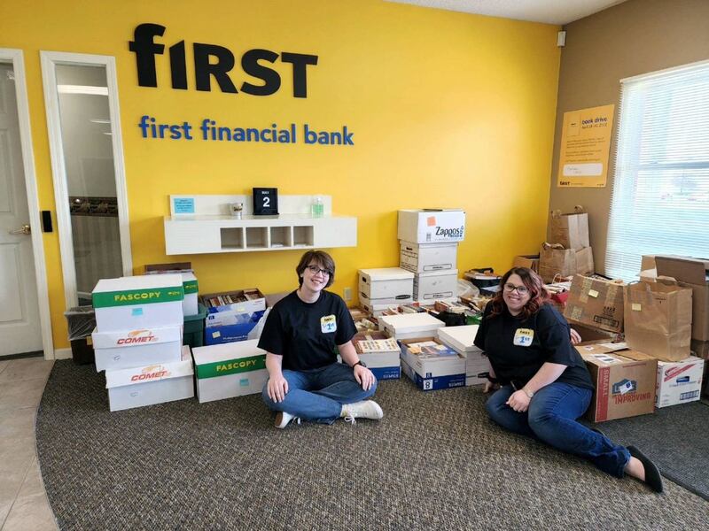 Staff at First Financial Bank in Kankakee sit with collected books after a past book drive.