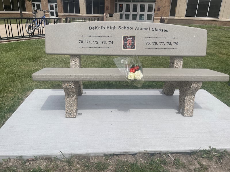 A new memorial bench has been created, installed, and is now permanently in place at the front of DeKalb High School, thanks to over 100 donors providing over $5,000 for the project spanning across all 10 classes in the ‘70s. The bench was celebrated on Friday, May 22, 2026, outside the high school as part of a ceremony with alumni in attendance.