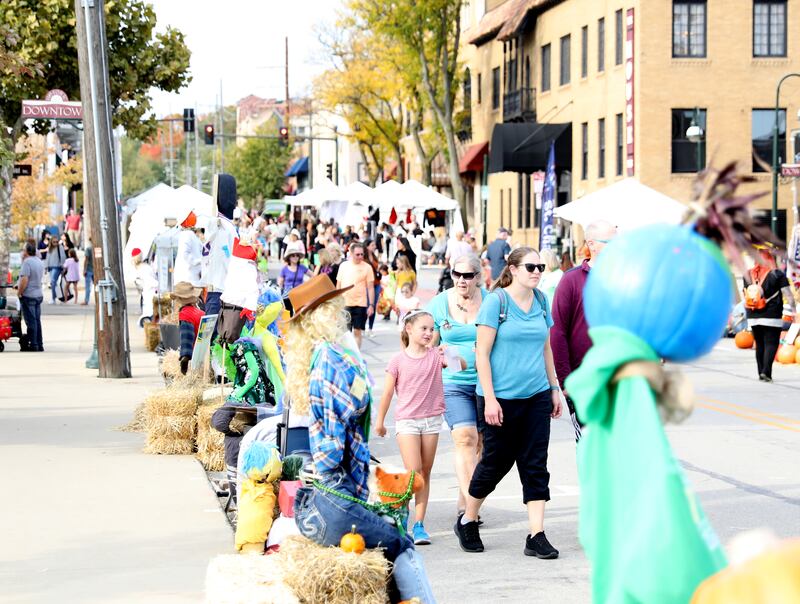 Spectators look at the scarecrows on display along Riverside Avenue on Friday, Oct. 11, 2024 during Scarecrow Weekend in downtown St. Charles.
