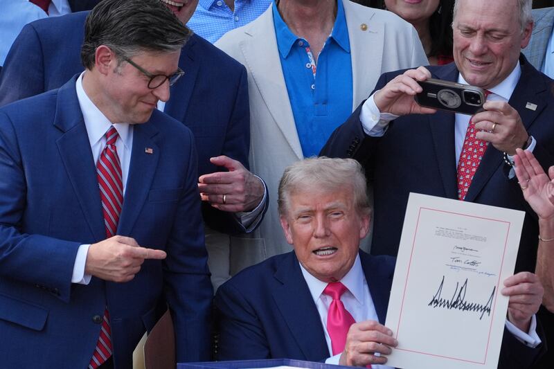 House Speaker Mike Johnson of La., points to President Donald Trump after he signed his signature bill of tax breaks and spending cuts at the White House, Friday, July 4, 2025, in Washington, surrounded by members of Congress. (AP Photo/Evan Vucci)
