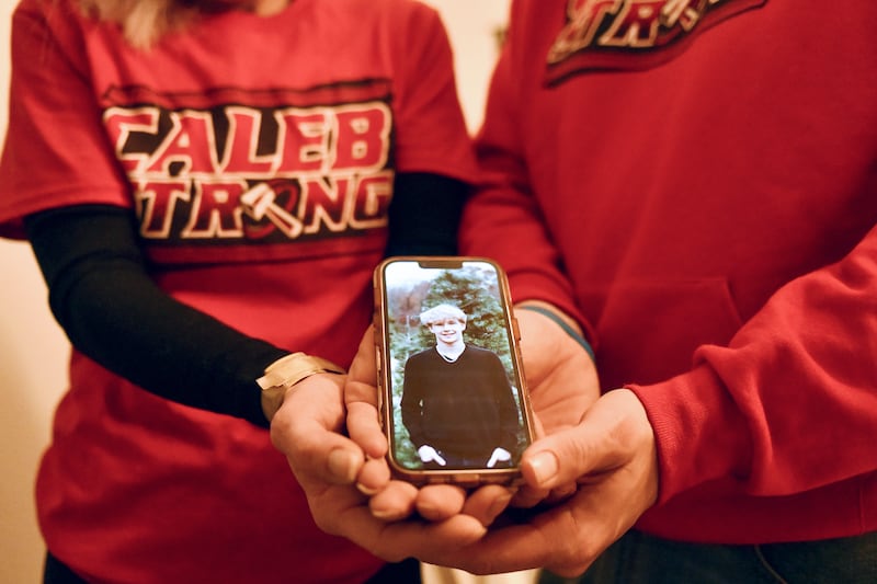 Jennifer and Nick Outerbridge hold a photo of their son, Caleb, a now 17-year-old BBCHS student, who is battling a rare autoimmune disorder affecting the brain known as ADEM. The family has fought to maintain hope with the help of overwhelming community support.