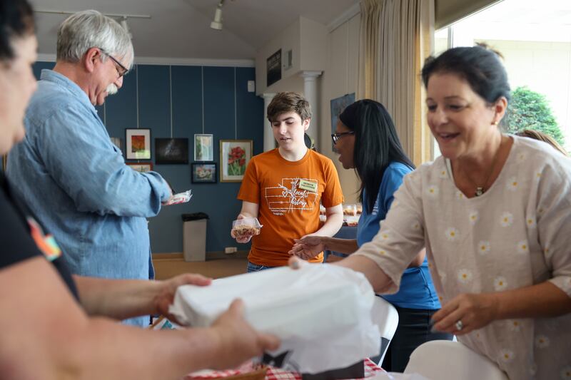 Kankakee County Museum volunteer Jack Shelling, 17, center, of Bourbonnais, helps sell slices of rhubarb and strawberry-rhubarb pie alongside fellow volunteers during the 35th annual Rhubarb Festival on Sunday, May 18, 2025.